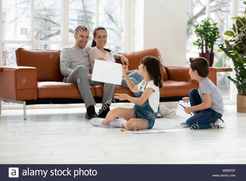 happy parents with kids in living room enjoy leisure