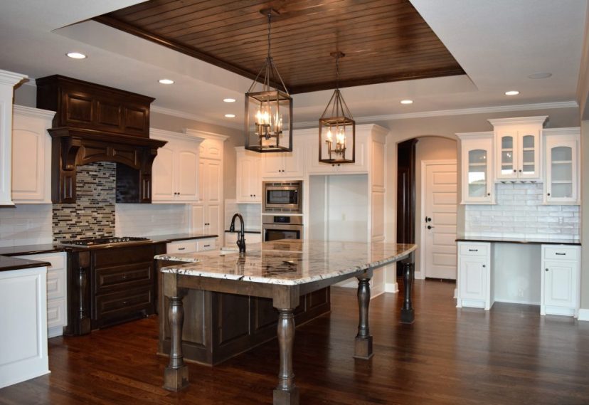 large granite island white cabinets wood ceiling accent
