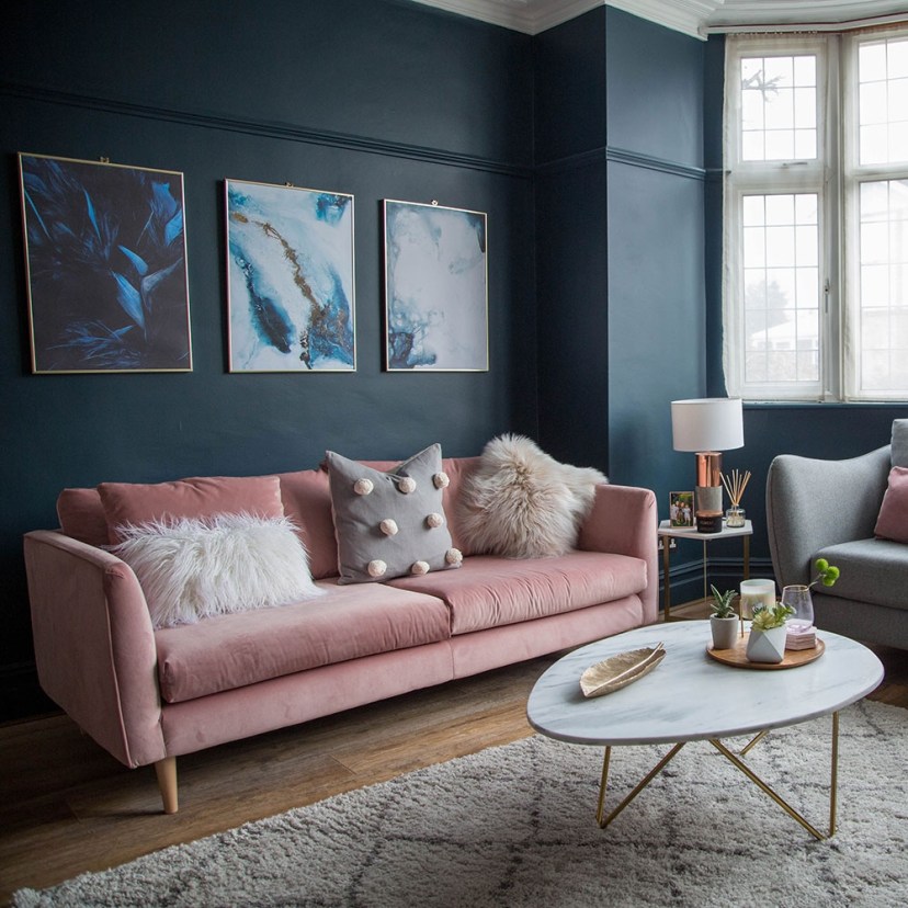 living room makeover with dark blue walls pink sofa and