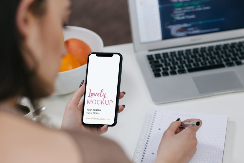 woman holding iphone x and taking notes lovely mockups